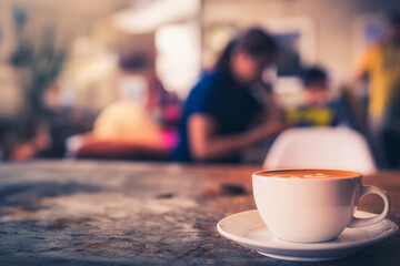 Cup of hot coffee on the table with coffee shop or cafe background in the morning