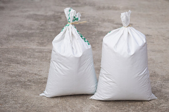 Two white polypropylene sack that contain full of agricultural grains, tied on the top with bamboo rope. Concept, reusable bag for contain crops, fertilizer or others.                      