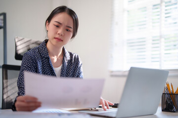 Businesswoman checking finance document and thinking about investment of business project to typing information on keyboard laptop while working and analysis about strategy marketing of new business