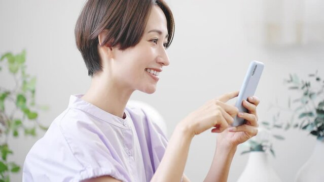 スマートフォンを操作する若い女性　ライフスタイルイメージ	
