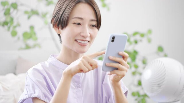 スマートフォンを操作する若い女性　ライフスタイルイメージ	
