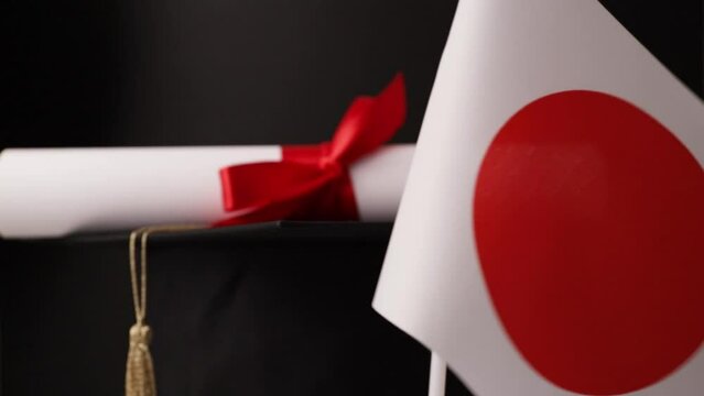 Japanese education and language learning, graduation cap with diploma and flag of Japan, international school celebrates learning success