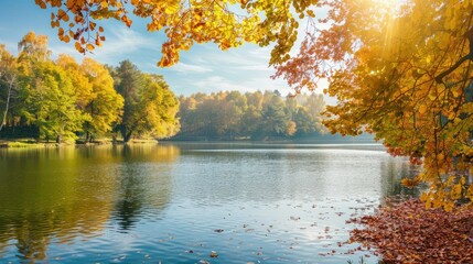 A scenic lake surrounded by trees with leaves changing colors from green to yellow