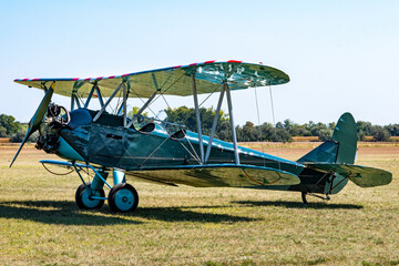 WWII green painted Soviet military biplane on a grass airfield © ZenitX
