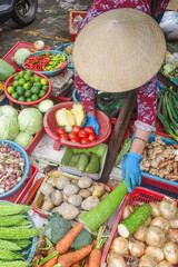 Hoi An, Vietnam - 5 Feb, 2024: Fruit and vegetable vendors wearing traditional Asian conical hats, Hoi An market, Vietnam