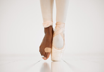 Hurt, foot and ballerina in class, dancing and balance of person on stage, plaster and injury in lesson. Studio, dancer and barefoot with bandage, pain and commitment to talent and training on floor © KayJoint/peopleimages.com