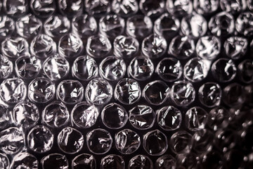 Close up of Plastic wrap air bubble packaging material on black background overlay texture