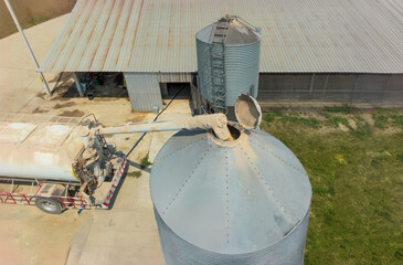 Feed truck delivering feed to the storage bins of chicken houses.