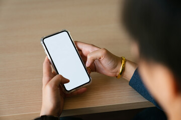 Close-up image of a woman wearing golden bracelet  and ring and using her smartphone. smartphone...