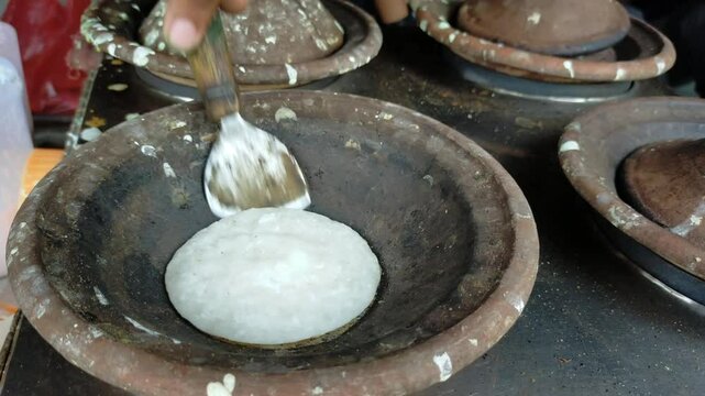 Making surabi, indonesia traditional pancake, in a clay pot.
