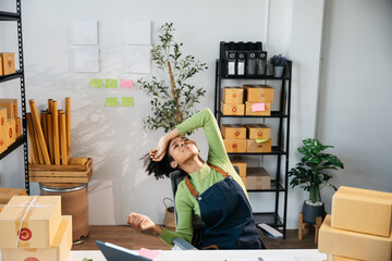 African Owner SME Small and Medium Enterprises woman stressed on lose money and orders the sales dropped in half from clients with products in parcel cardboard box packaging ready for delivery