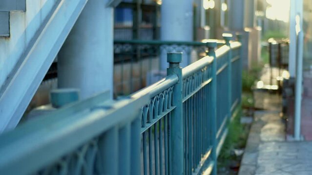 View of the station's outer fence with bokeh background, flares, yellowish morning sunlight