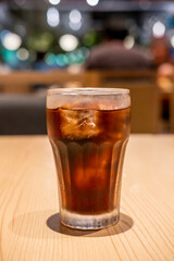 A glass of Cola on the table with bokeh background