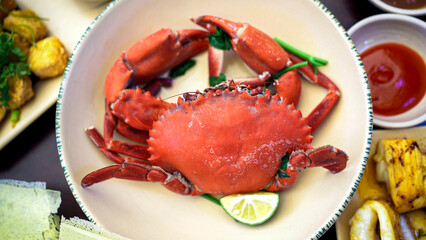 A Vietnamese dish of cooked crab garnished with fresh herbs, served in a bowl.