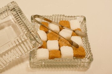 white and brown sugar cube in the crystal box on the table