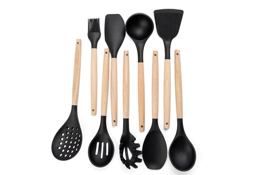 A set of wooden kitchen utensils including a spatula, ladle, and whisk. The utensils are black and wooden, and they are arranged in a row - Powered by Adobe