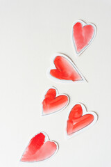 five retro paper hearts on blank paper