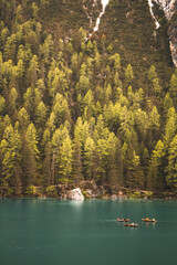 Ruderboote auf einem klaren Bergsee umgeben von dichtem Wald