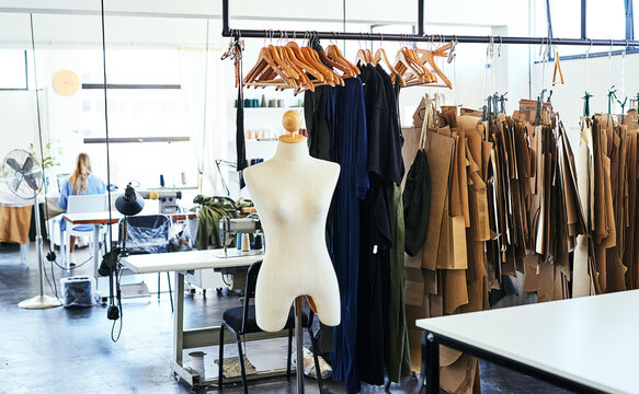 Textile, fashion designer and woman with mannequin, design studio and garments in atelier or small business. Female tailor, dressmaker and clothing rack for designs or couture with person in boutique
