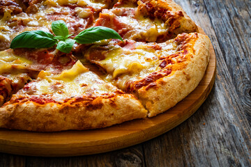 Pizza Serrano with cured ham, mozzarella cheese and mushrooms on wooden table
