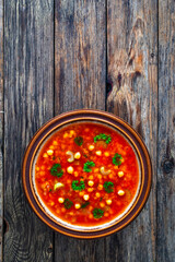 Moroccan cuisine - harira fresh vegetable soup top view  with chickpeas and lentil served in old style bowl on wooden table
