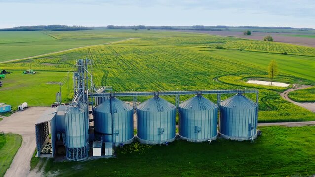 Aerial view over agro silos granary elevator on agro-processing manufacturing plant for processing drying cleaning and storage of agricultural products. Farm building and grain storage bins