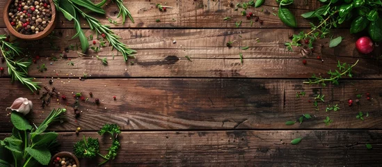 Herbs and spices on wooden background seen from above with space for text © Lasvu