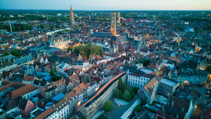 Enchanting aerial view of Bruges' historic old town captured by a drone at night! The illuminated medieval architecture, winding canals, and charming cobblestone streets create a magical and captivati