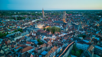 Enchanting aerial view of Bruges' historic old town captured by a drone at night! The illuminated medieval architecture, winding canals, and charming cobblestone streets create a magical and captivati