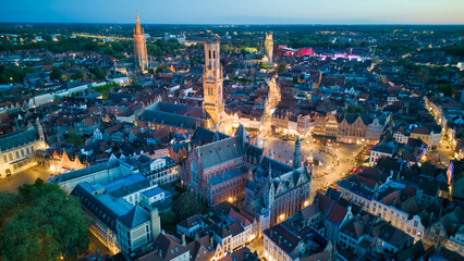 Enchanting aerial view of Bruges' historic old town captured by a drone at night! The illuminated medieval architecture, winding canals, and charming cobblestone streets create a magical and captivati