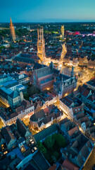 Enchanting aerial view of Bruges' historic old town captured by a drone at night! The illuminated medieval architecture, winding canals, and charming cobblestone streets create a magical and captivati