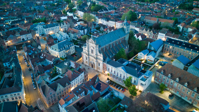 Enchanting aerial view of Bruges' historic old town captured by a drone at night! The illuminated medieval architecture, winding canals, and charming cobblestone streets create a magical and captivati
