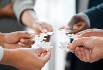 Teamwork, hands and business people in office with puzzle, problem solving and critical thinking...