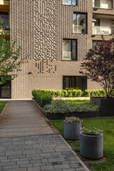  A fragment of a residential building and the surrounding area with landscaping