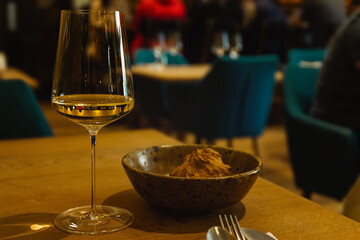 A glass of white wine at the bar. a glass of white wine in a restaurant, alcohol background