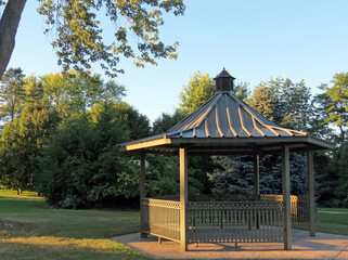 The evening sun gilds a gazebo in the park.