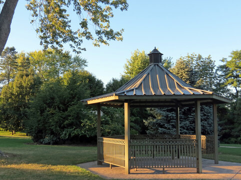 The evening sun gilds a gazebo in the park.