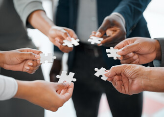 Hands, business people and team with puzzle piece for solidarity, synergy and connection together. Jigsaw, group and worker with trust for collaboration, cooperation and problem solving for solution