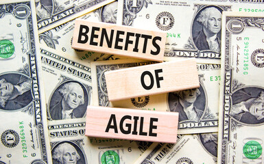 Benefits of agile symbol. Concept words Benefits of agile on beautiful wooden blocks. Dollar bills. Beautiful dollar bills background. Business benefits of agile concept. Copy space.