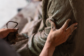 Selective focus sculptor hand molding clay.Professional artist worker creating a statue sculpture...