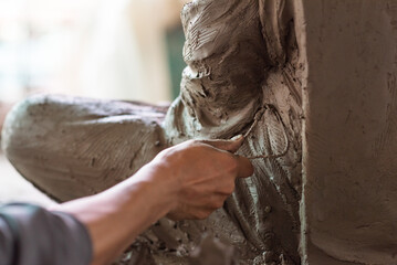 Selective focus sculptor hand molding clay.Professional artist worker creating a statue sculpture with wet clay.Handicraft production.