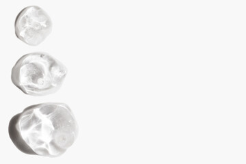 drops of cosmetic texture transparent gel on light background