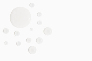 drops of cosmetic texture transparent gel on light background