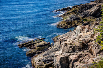 Rocky shoreline of Acadia National Park on calm weather day in early summer