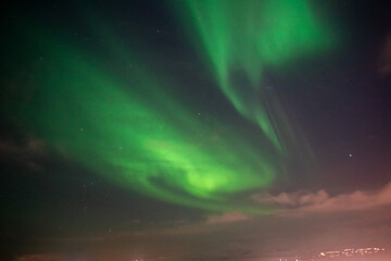Strong Auroras spiraling over Tromso city lights