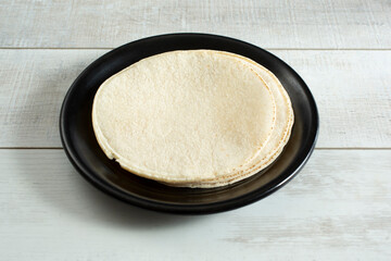 A view of a stack of corn tortillas on a plate.