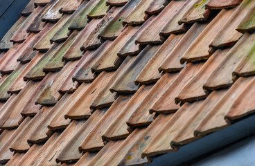 Hausdach mit alten braunen Dachziegeln aus Ton, perspektivisch
