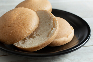 A view of sliced gluten-free buns on a black plate.