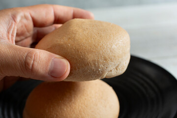 A view of a hand holding a gluten-free bun.