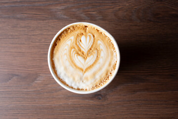 A top down view of a latte coffee drink, featuring latte art.